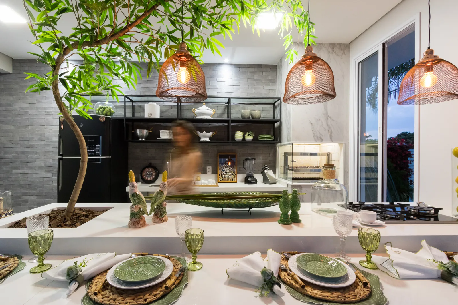 Photo: dining counter set under copper pendants, with a tree planted in the counter